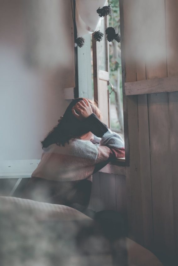 photo of a person leaning on wooden window